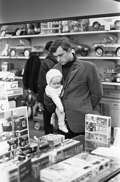 Father and baby son browse the latest Lego sets in the toy department of Heelas