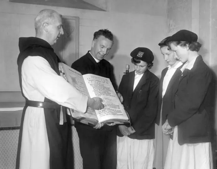 : Father Celsus shows some visitors one of the monastery books at Mount Saint Bernard in : Father Celsus shows some visitors one of the monastery books at Mount Saint Bernard in