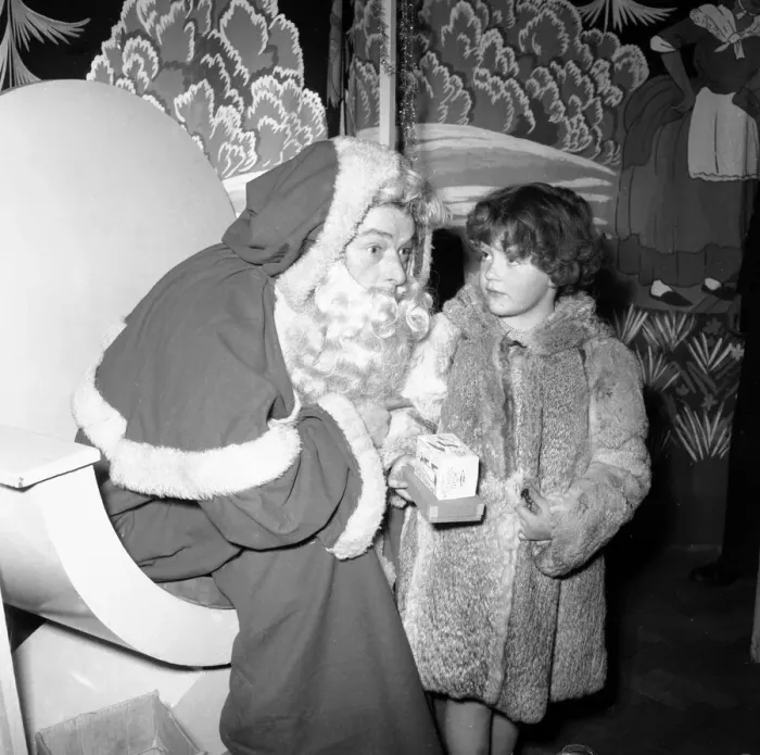 Framed Print : Father Christmas Harry Proctor seen here giving a gift to a small girl at the daily