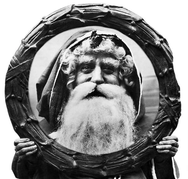 Father Christmas looking through a Holly Wreath. 12th December 1921