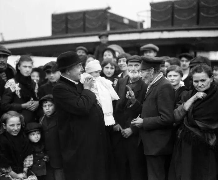 Framed Print : Father Merckx seen here with one of the youngest of the 300 Belgian refugees aboard a