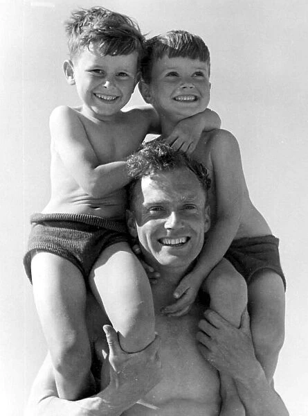 A father with his two young sons sitting on his shoulder Circa 1945 P044436