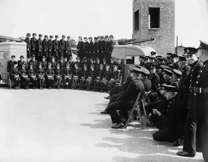Framed Print : Female firefighters pose with their commandant for a photograph before leaving their