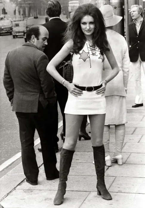Framed Print : Female model Beulah Hughes wearing a mini dress and knee high boots in a London street as