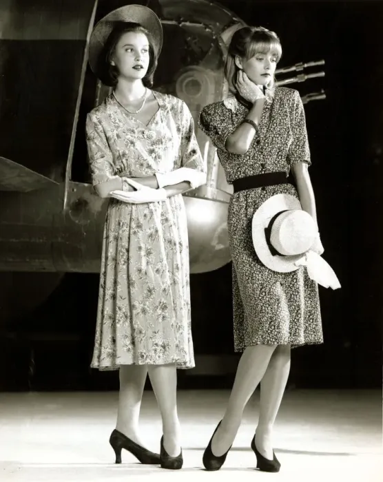 Framed Print : Two female models wearing 40s style evening dress with floral print holding a hat in one Framed Print : Two female models wearing 40s style evening dress with floral print holding a hat in one