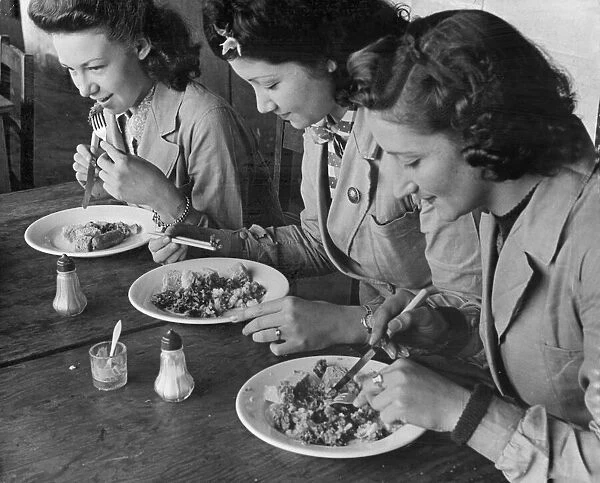 Female munition workers enjoy their lunch. The chef has given the chinese lady in