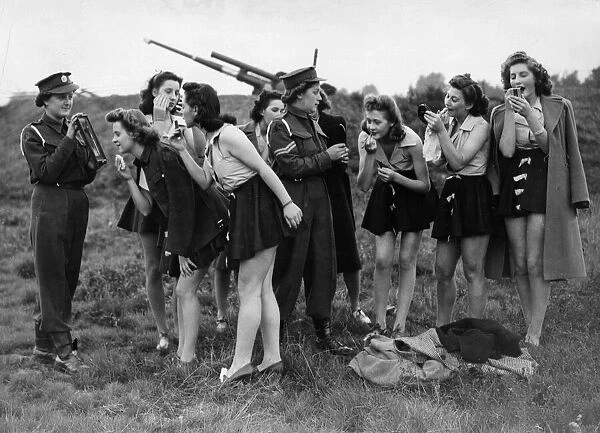 Female munition workers of a London war factory put on their make-up before staging a