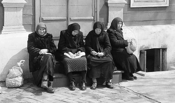 Female residents of the Soviet city of Kiev, sitting together on the steps of a building