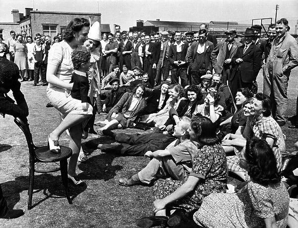 Female ventriloquist entertaining workers during the second world war. 30th June 1942