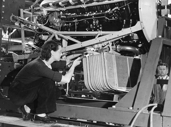 A female worker inspecting the cooling system of a Lancaster bomber plane of the Royal