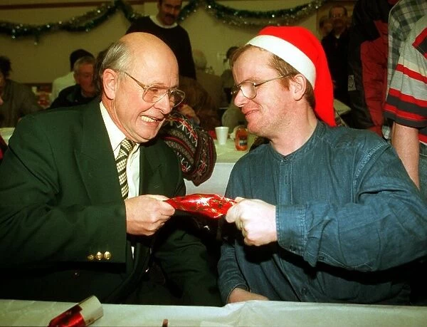 Fergus McCann pulls a cracker with Craig who Aattended a lunch for the homeless at St