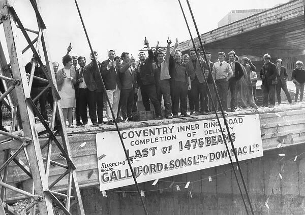 Fifty men with a bottle of beer each to celebrate the lowering into position of the last