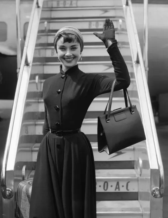 Framed Print : Film actress Audrey Hepburn waves as she stands in front of the steps of her plane Framed Print : Film actress Audrey Hepburn waves as she stands in front of the steps of her plane