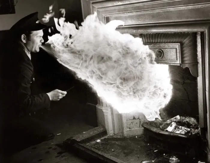 Framed Print : fire eater - man blowing flames from mouth to light logs in fireplace Framed Print : fire eater - man blowing flames from mouth to light logs in fireplace