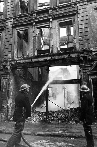 Fire fighters in the City of London following air raid attacks. Circa 1941