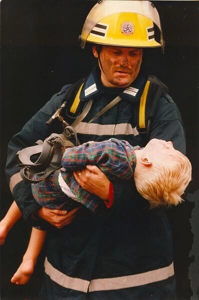 A firefighter rescus a young boy from a fire 01  /  06  /  95 circa - posed by models