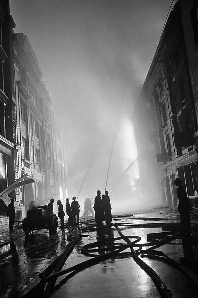 Firefighters of the Auxiliary Fire Service attend the scene of a blazing building near