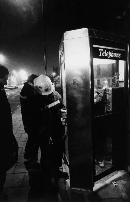 Framed Print : Firefighters free a youngter from a telephhone box jammed shut by his friends