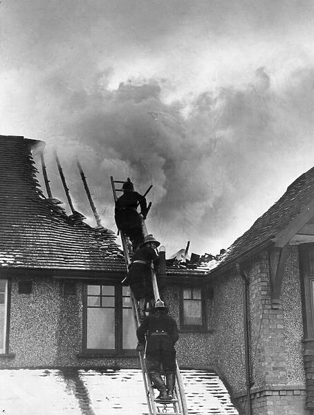 Firemen attend to a roaring blaze at a house on Tilehurst Road