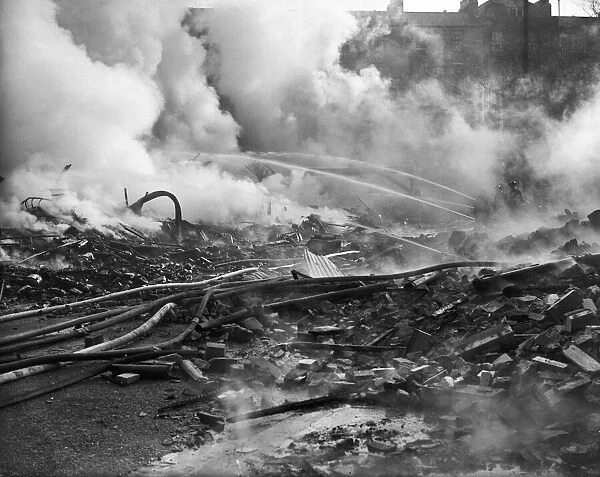 Firemen dampen down the fires caused by a a Luftwaffe attack on the City of Bristol