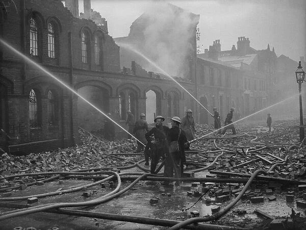 Firemen dampening down fires in Moseley Street, Birmingham the morning after a heavy
