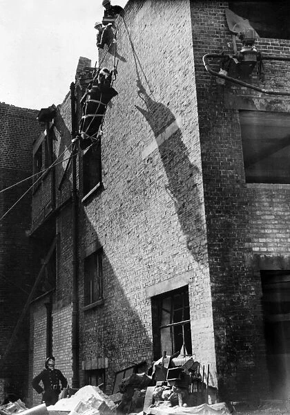Firemen lower an injured man from the roof after rescuing him from the debris follow a V1