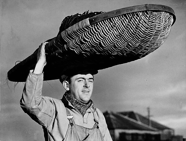 Fisherman David Beattie on his way to mend his nets carrying a huge basket on his head