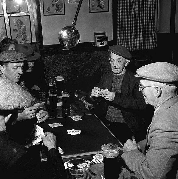 Fisherman around the table playing cards in a pub in St Ives in Cornwall February