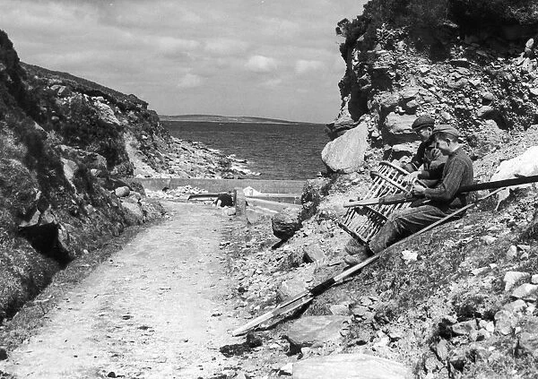Fishermen seen here on Achill Island County Mayo Ireland repairing their lobster pots