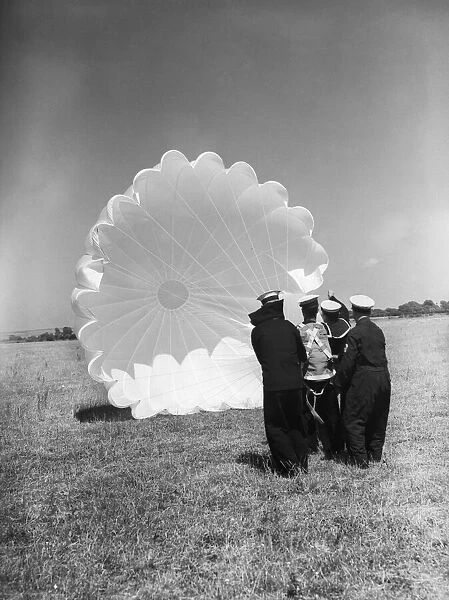 Fleet Air Arm parachute packers seen here testing a parachute at an un-named Royal Naval
