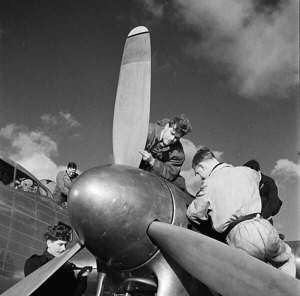 Flight engineers work on the Rolls Royce Merlin engines of a BOAC Lancastrian at Hurn