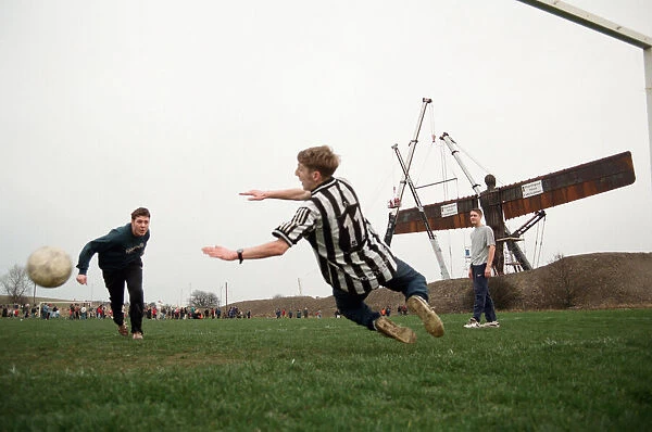 A football game takes place in front of the Angel of the North, Gateshead