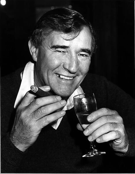 Football manager Malcolm Allison with a cigar and a glass of wine. Circa 1975