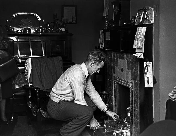 Footballer Billy Wright Wolves and England captain seen here putting coal on the fire at