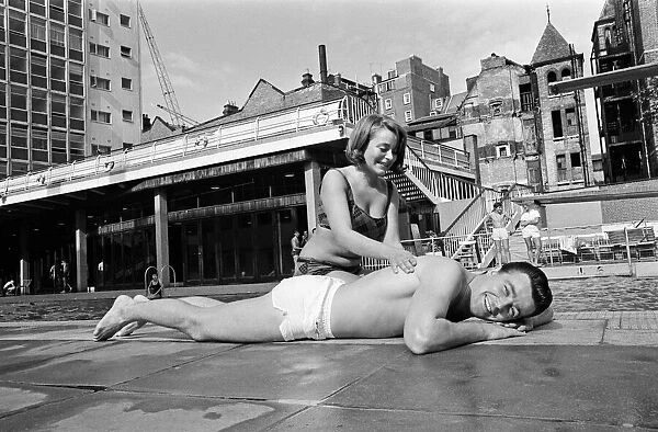 Footballer Johnny Byrne relaxing at oasis swimming baths. 21st August 1964