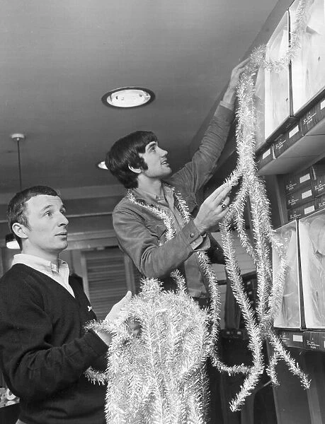 Footballers George Best and Mike Sumerbee make a start on the festive decorations at