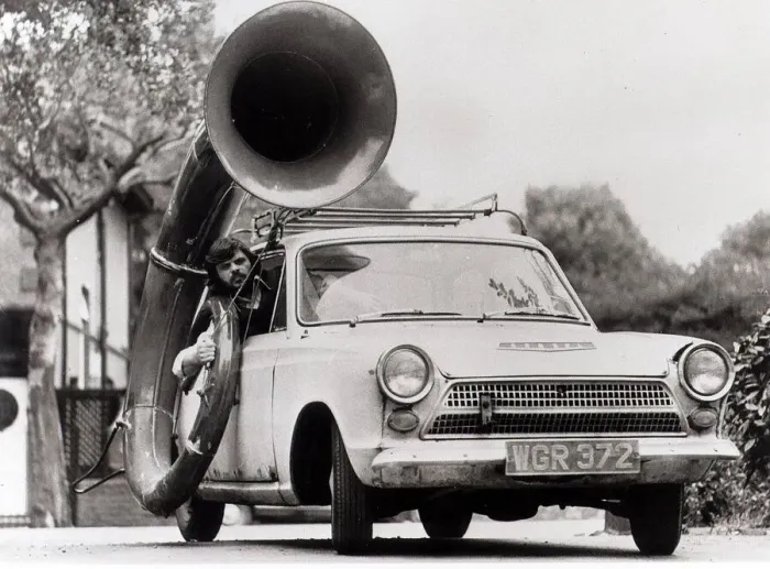 Framed Print : Ford Cortina Mk1 Car. A man drives the car with a large horn instrument strapped to