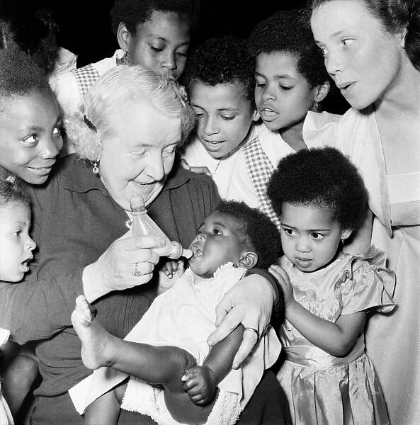 Foster Mother, Mrs. Ada Wheeler seen here bottle feeding one of her younger foster