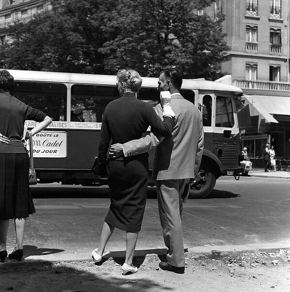 France Paris -A man with his arm around the waist of his girlfriend waits to cross