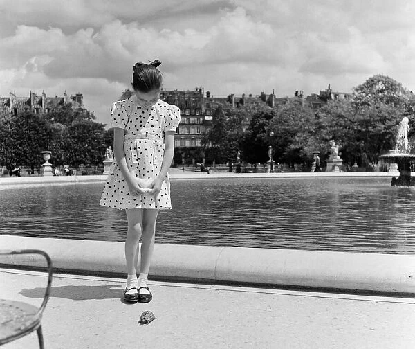 France Paris -A young girl takes her Tortoise for a walk in the park during the state of