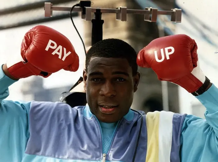 Framed Print : Frank Bruno Boxing Standing under tv aerial wearing boxing gloves