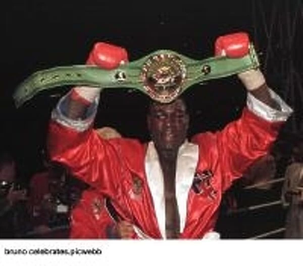 Frank Bruno holds up his WBC world title belt after he had beaten Oliver McCall in his