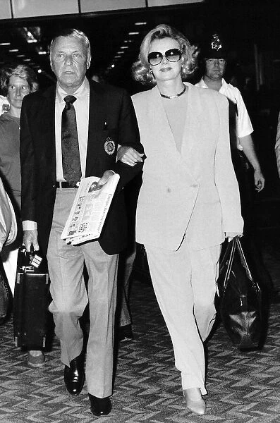 Frank Sinatra Walking with a woman holding a case and a newspaper