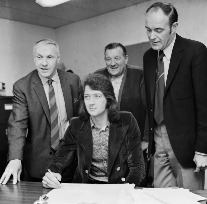 Framed Print : Frank Worthington signs for Liverpool from Huddersfield Town at Anfield watched by Framed Print : Frank Worthington signs for Liverpool from Huddersfield Town at Anfield watched by