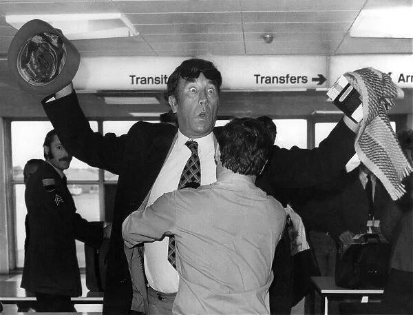 Frankie Howerd being searched by a security guard at Londons Heathrow Airport