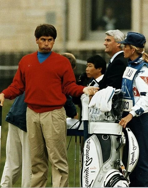 Fred Couples gesturing to wife Barbara who is his caddie fans in background golf