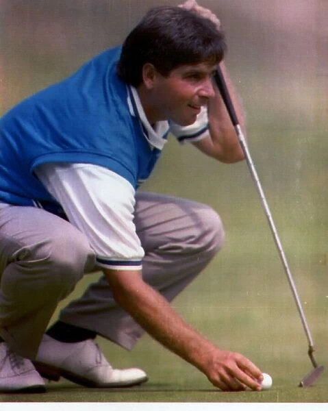 Fred Couples golf kneeling on green and holding golf ball and putter