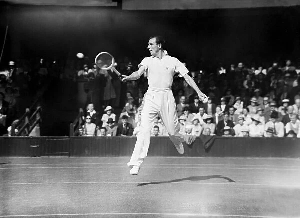 Fred Perry (GB) jumps to play a back hand ball at the Wimbledon Tennis Championships