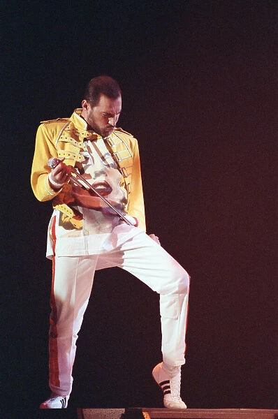 Freddie Mercury, lead singer of rock group Queen, performing on stage
