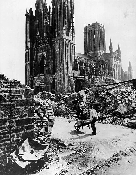 French civilians clearing rubble of destroyed houses beside the church in Periers, France
